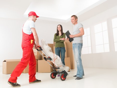 Removal team handling furniture in a narrow street